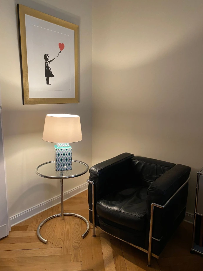 Moderne Tischlampe mit warmem Licht vor grauer Wand