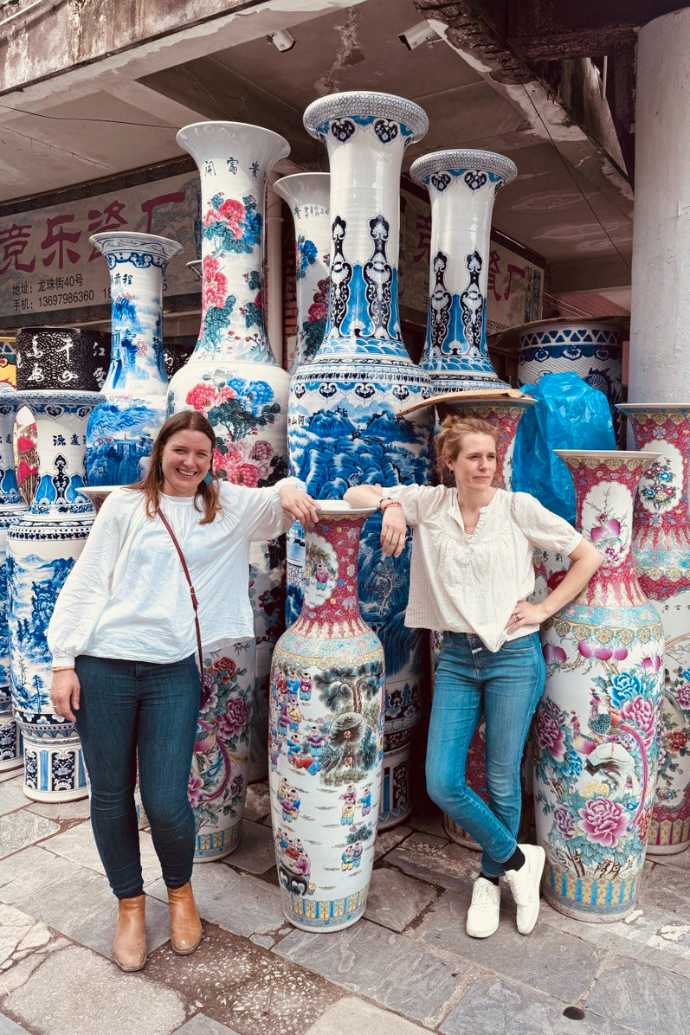 Gründerin in einer Keramikmanufaktur zwischen handbemalten Vasen