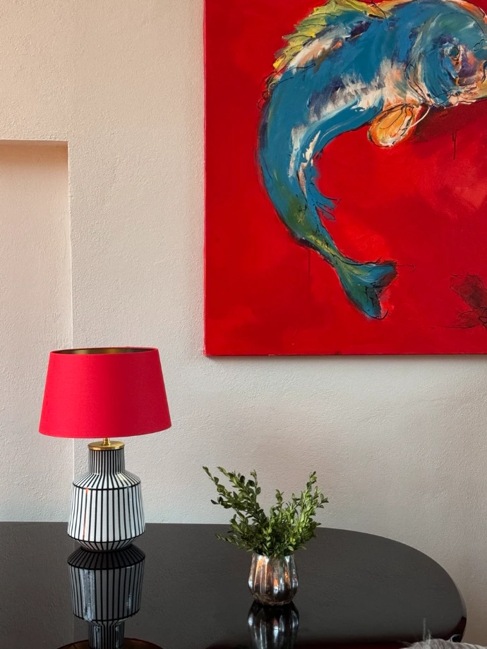 Keramiklampe mit rotem Lampenschirm im Wohnzimmer